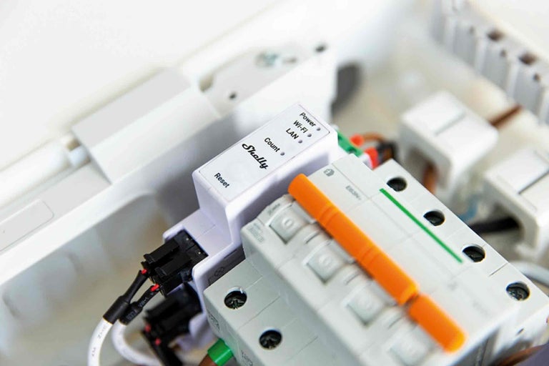 Logo Shelly et un compteur d'énergie dans un coffret de distribution