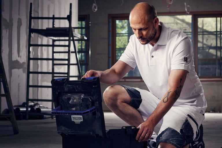 Artisan avec une boîte à outils dans une pièce avec un échafaudage