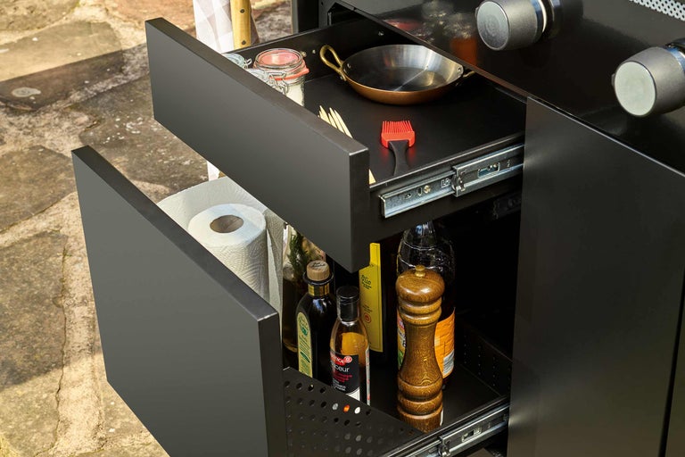 Tiroirs ouverts d'un placard de barbecue avec ustensiles de cuisine et ingrédients