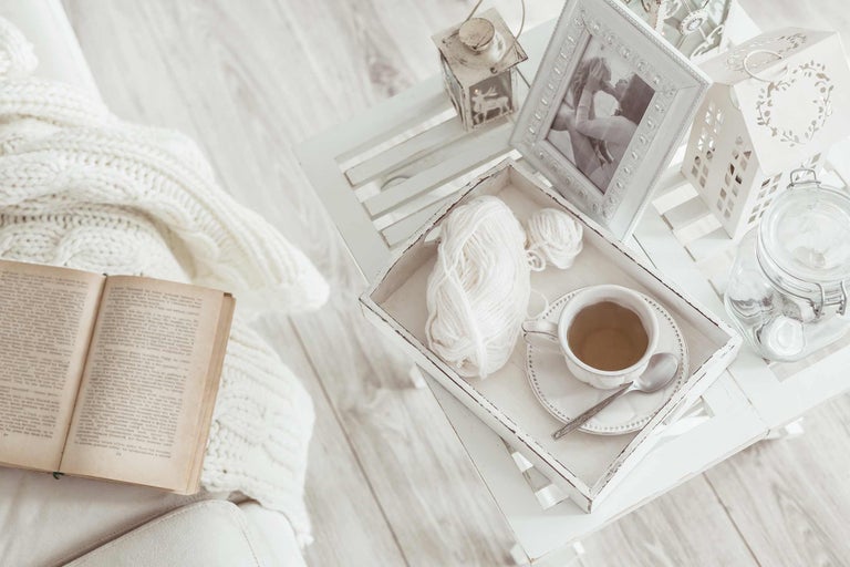 Scène décorative avec livre, couverture, table d'appoint et tasse à thé pour une ambiance chaleureuse