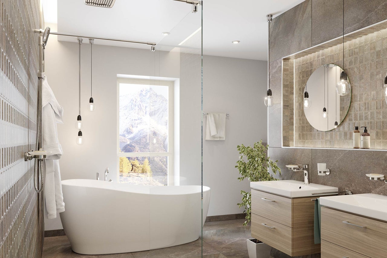 Salle de bains lumineuse avec baignoire, lavabos, miroir et fenêtre avec vue sur la montagne