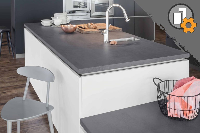 Îlot de cuisine avec plan de travail, évier et robinetterie, ainsi que vaisselle et aliments