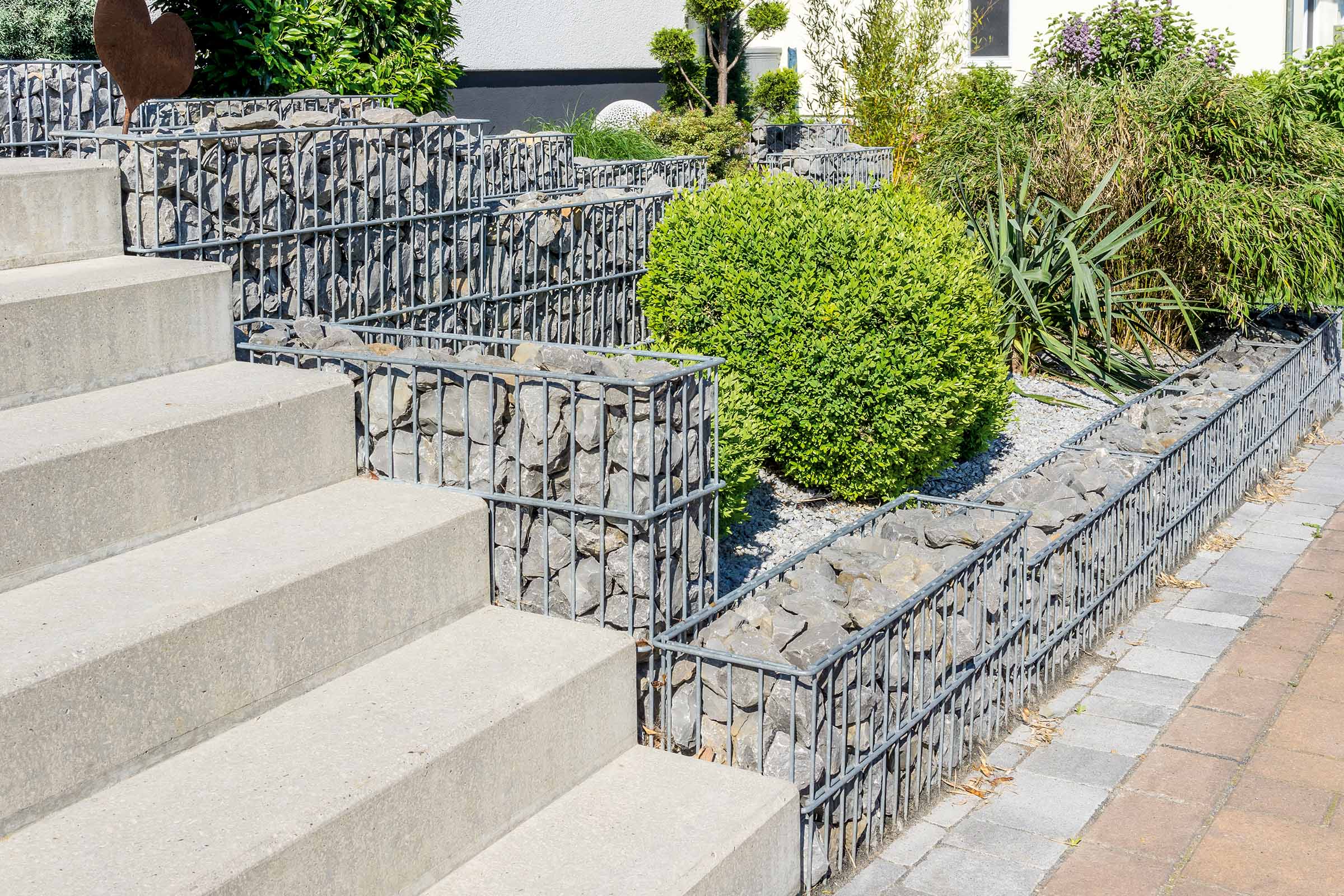 Gartenlandschaft mit Gabionen, Steintreppe und Bepflanzung