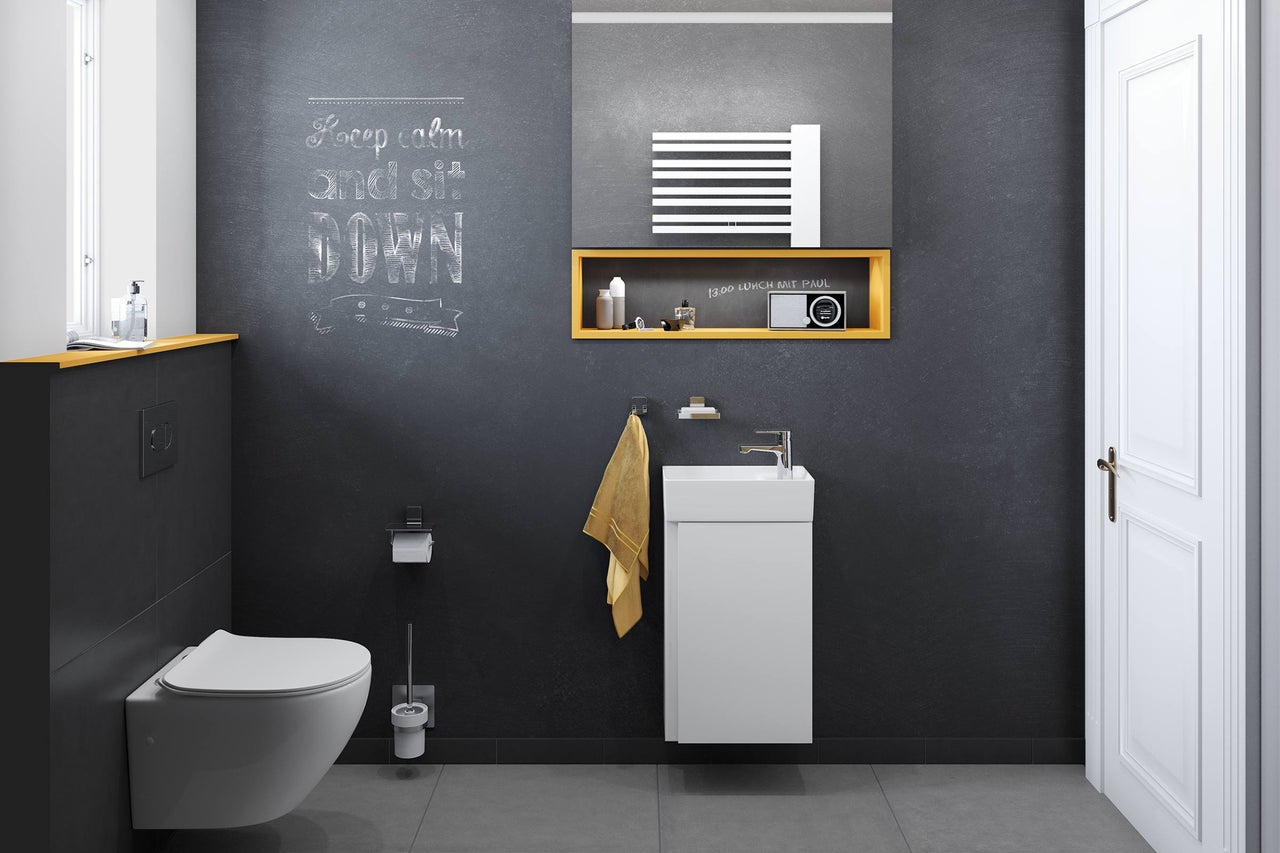 Salle de bains moderne avec toilettes, meuble sous-vasque, miroir et accessoires.