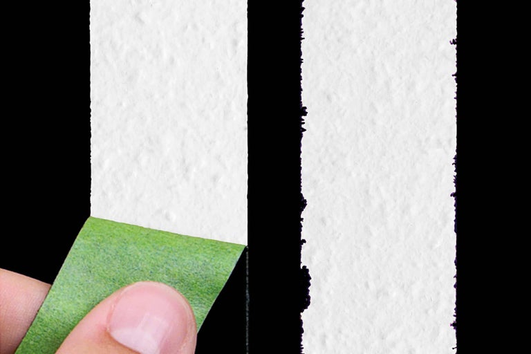 Abziehen von Malerkrepp von einer frisch gestrichenen Wand