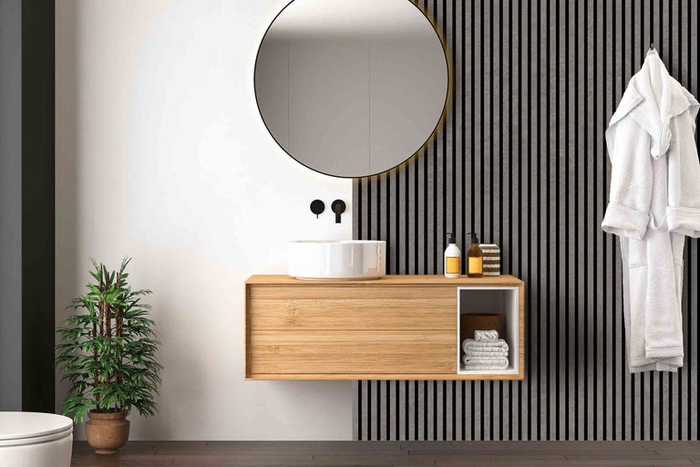 Salle de bains moderne avec meuble-lavabo en bois, miroir rond et plante d'intérieur