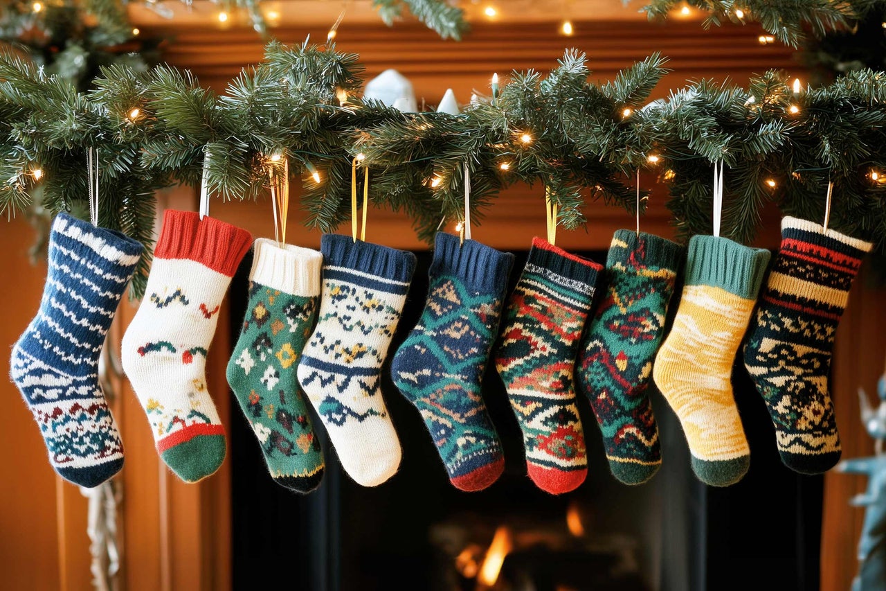 Dekorativer Kamin mit Weihnachtsgirlande und bestickten Strümpfen für festliche Atmosphäre