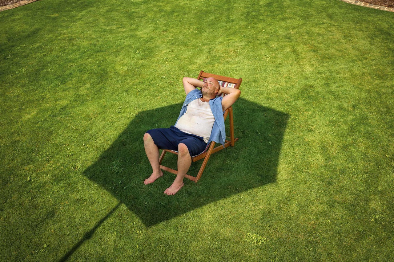 Homme se détendant dans une chaise longue sur une pelouse