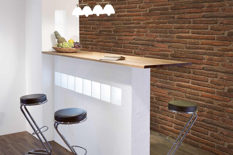 Bar mit Holzplatte, Barhockern und Backsteinwand