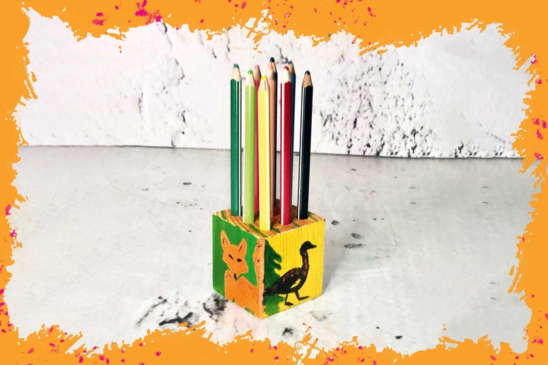 Crayons de couleur dans un pot à crayons en bois avec des motifs d'animaux