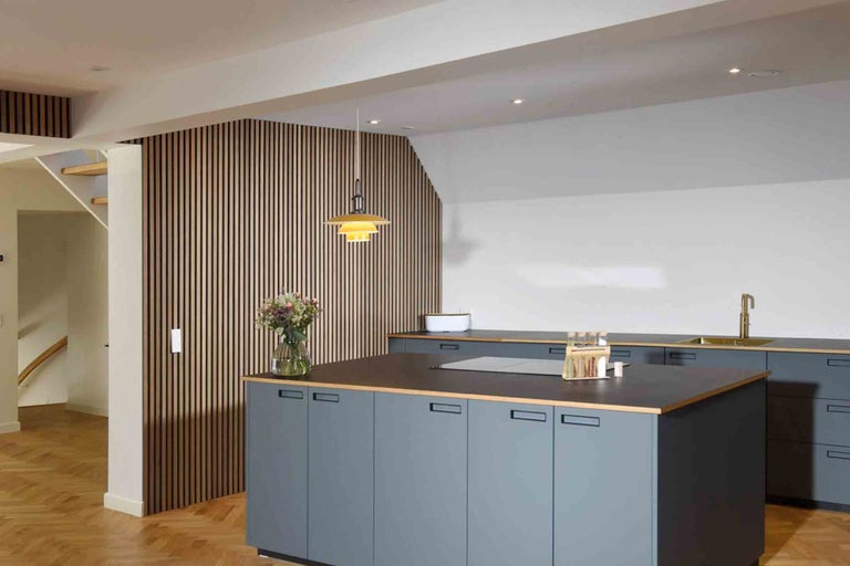 Cuisine moderne avec îlot de cuisine, panneaux muraux en bois et suspension