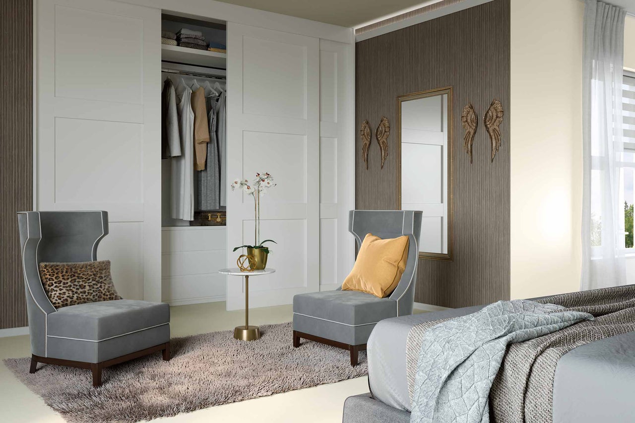 Chambre avec armoire, deux fauteuils, tapis et décoration