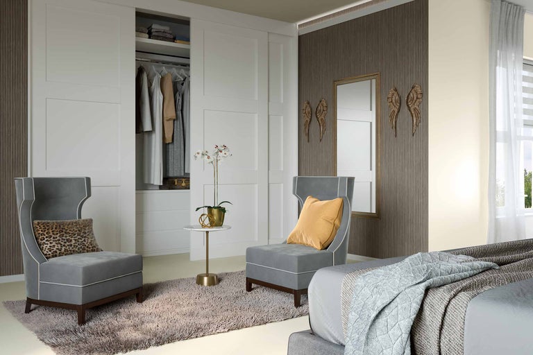 Schlafzimmer mit Kleiderschrank, zwei Sesseln, Teppich und Dekoration