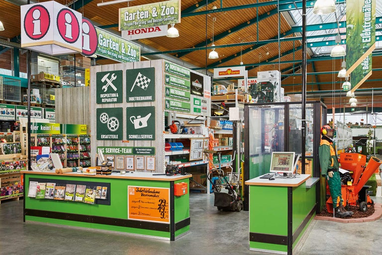 Vue intérieure du centre de jardinage Hornbach avec espace service pour machines de jardin, panneaux d'information et rayons de produits