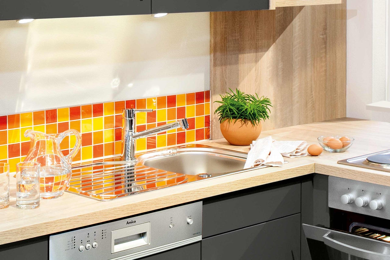 Scène de cuisine avec évier, robinet, lave-vaisselle et plaque de cuisson