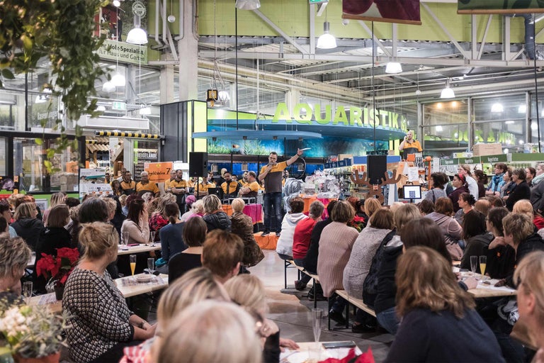 Événement dans un magasin Hornbach avec public et scène dans le secteur de l'aquariophilie.