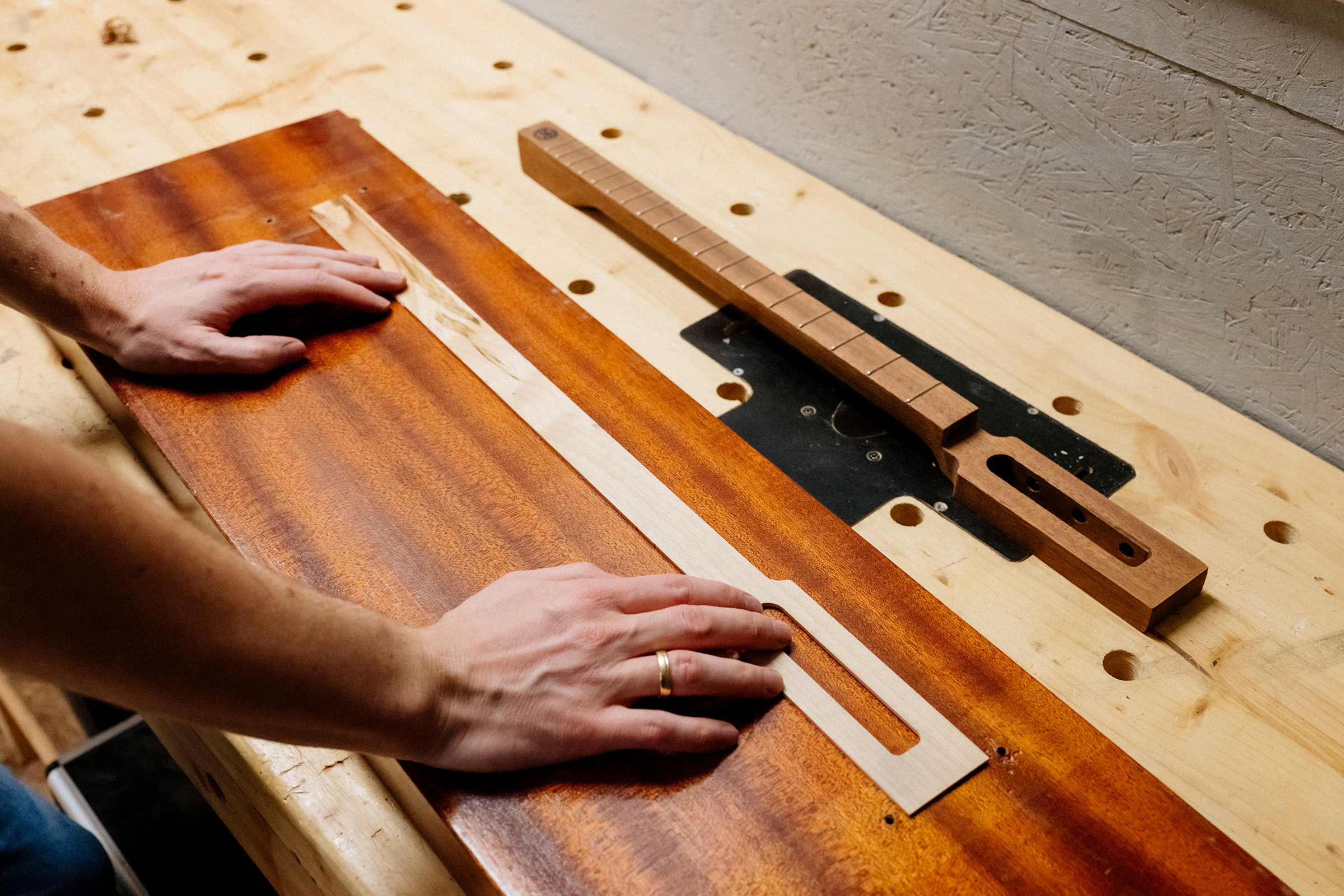 Gitarrenbau: Holzzuschnitt und Hals auf einer Werkbank