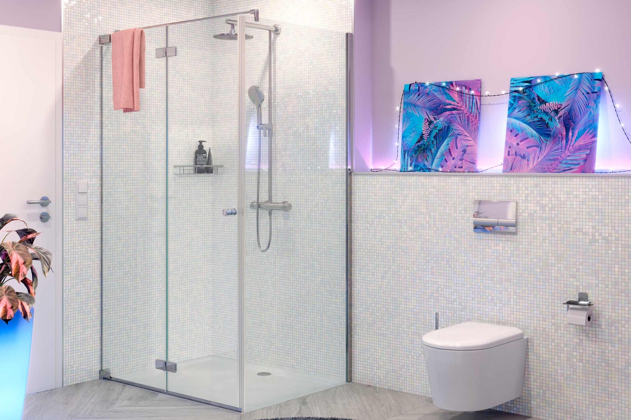 Salle de bain avec cabine de douche en verre, toilettes et décoration