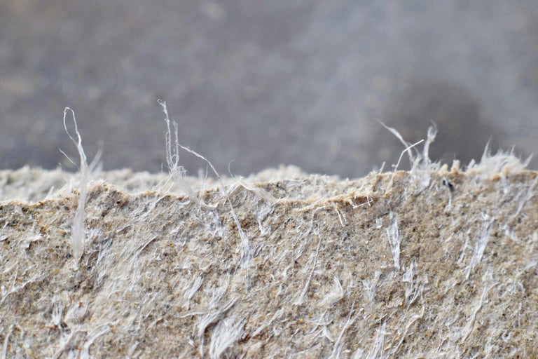 Gros plan d'une plaque d'amiante avec des fibres apparentes