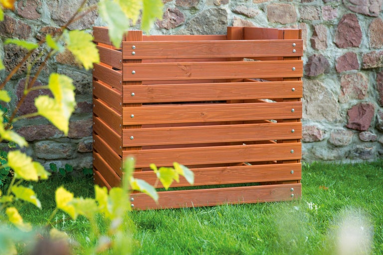 Holz-Mülltonnenbox zur Aufbewahrung im Garten vor einer Steinmauer