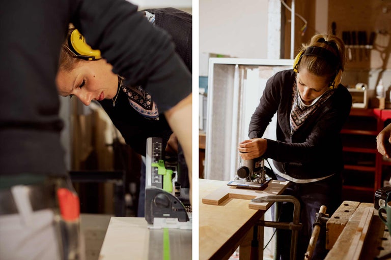 Une femme travaille sur une pièce de bois avec une défonceuse et une protection auditive.