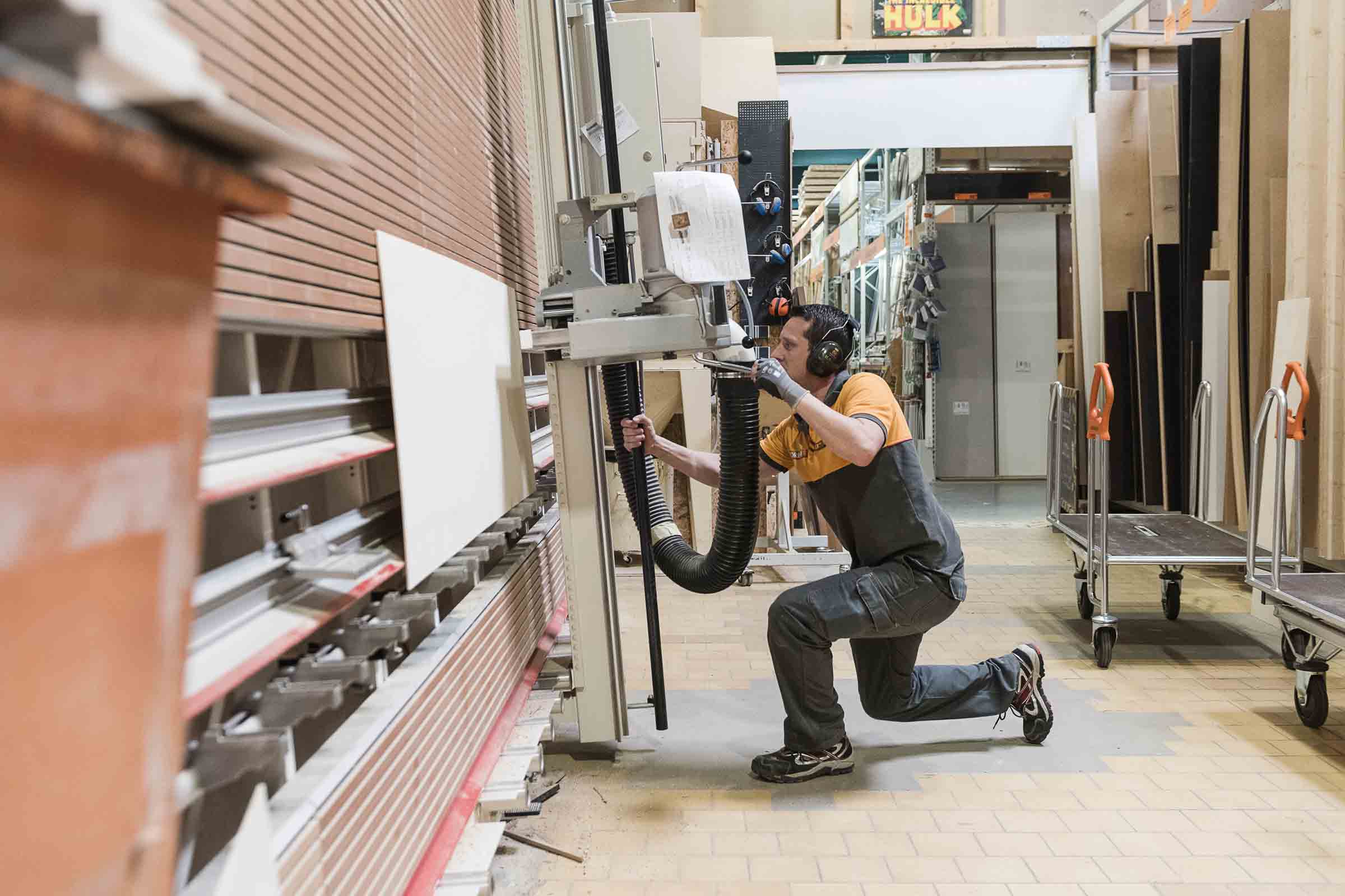 Un homme utilise une scie à panneaux dans le commerce de bois Hornbach.