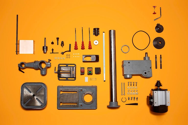 Pièces détachées d'une perceuse à colonne sur fond jaune