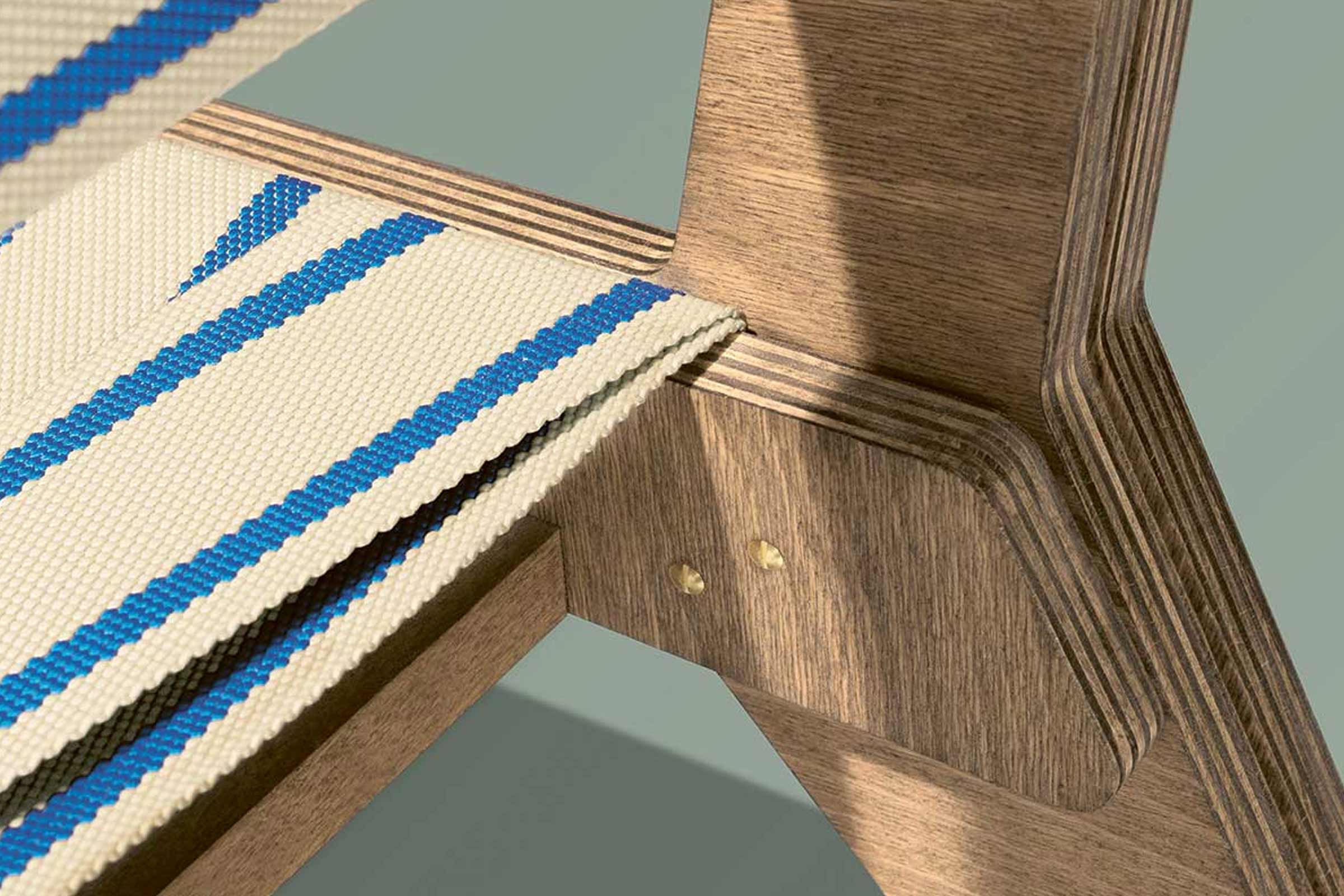 Detailansicht eines Holzstuhls mit Stoffbezug und blauen Streifen