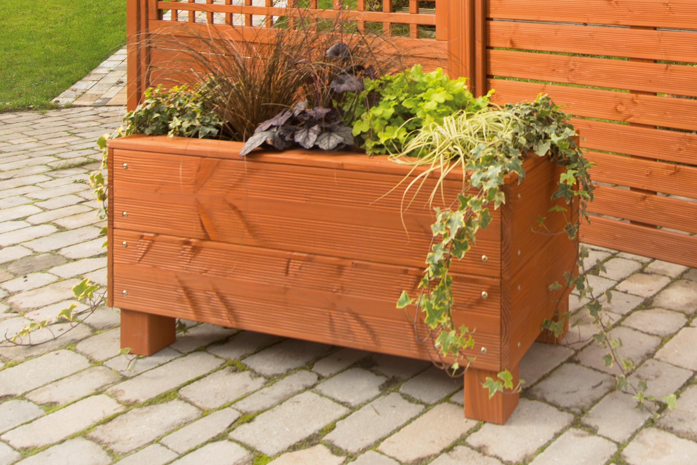 Jardinière en bois avec plantations dans le jardin