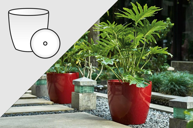 Cache-pot décoratif avec plante dans le jardin