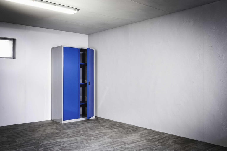 Armoire en acier avec étagères et portes battantes dans une pièce lumineuse