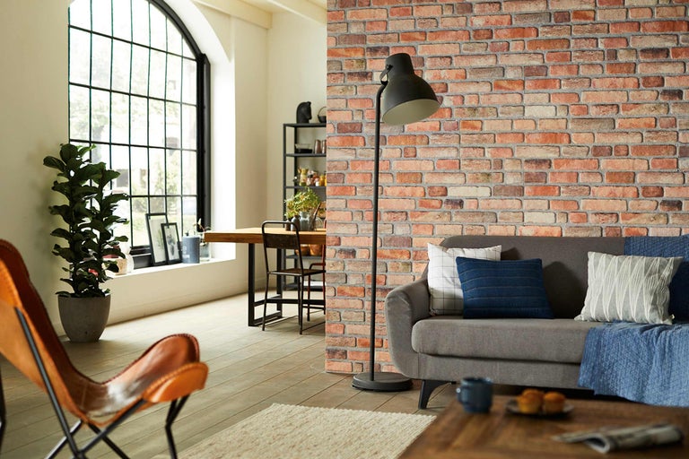Wohnzimmer mit Ziegelwand, Stehlampe und Ledersessel