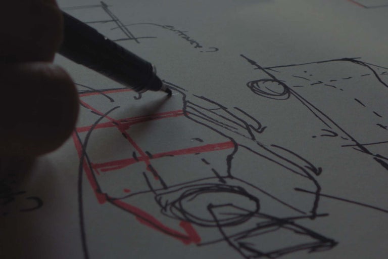 Main dessinant un croquis technique avec un stylo sur du papier