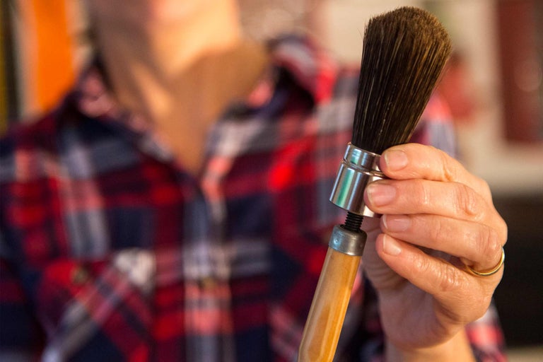 Rundpinsel mit Holzgriff in der Hand