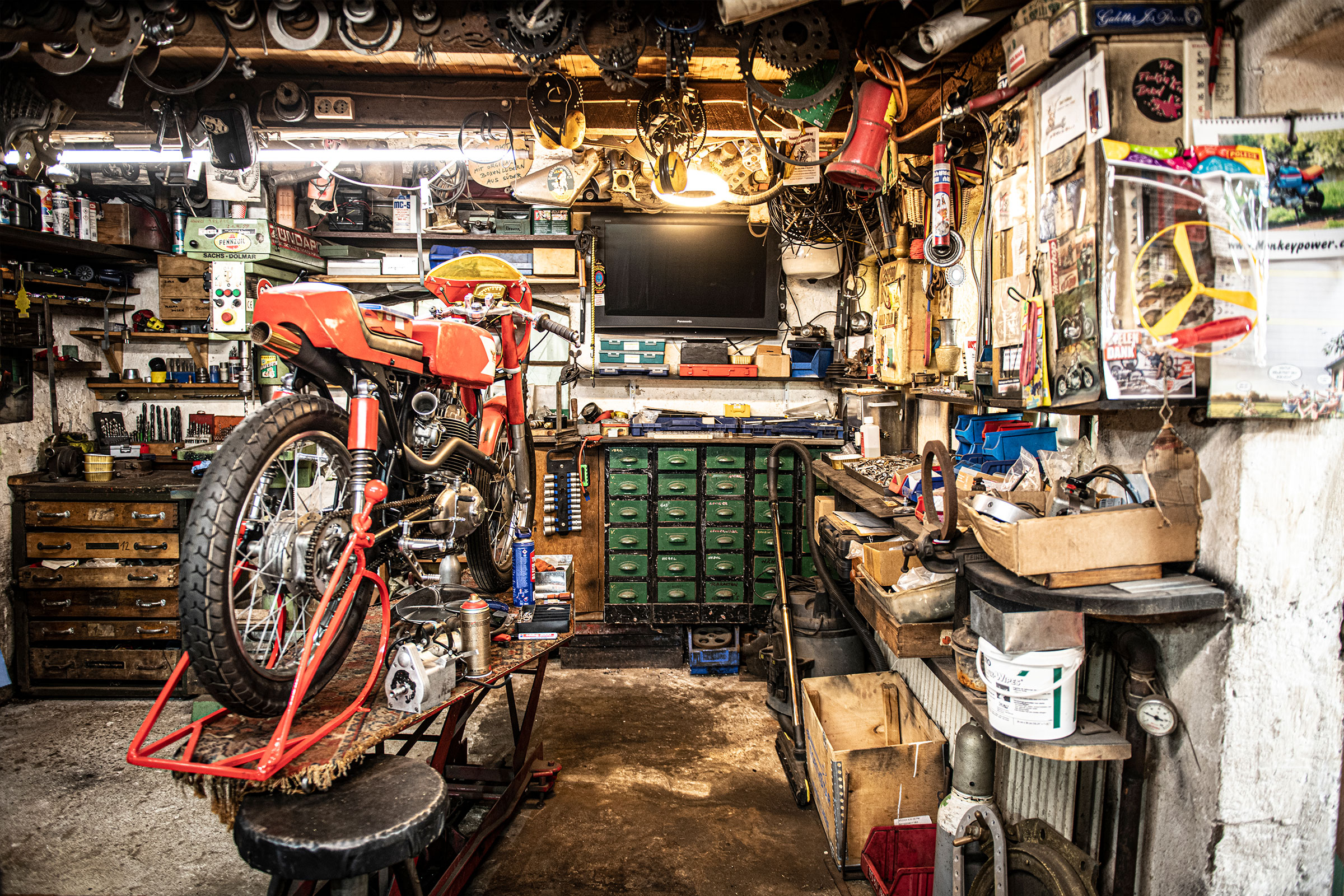 Werkstatt mit Motorrad auf Hebebühne, Werkzeug und Werkbank