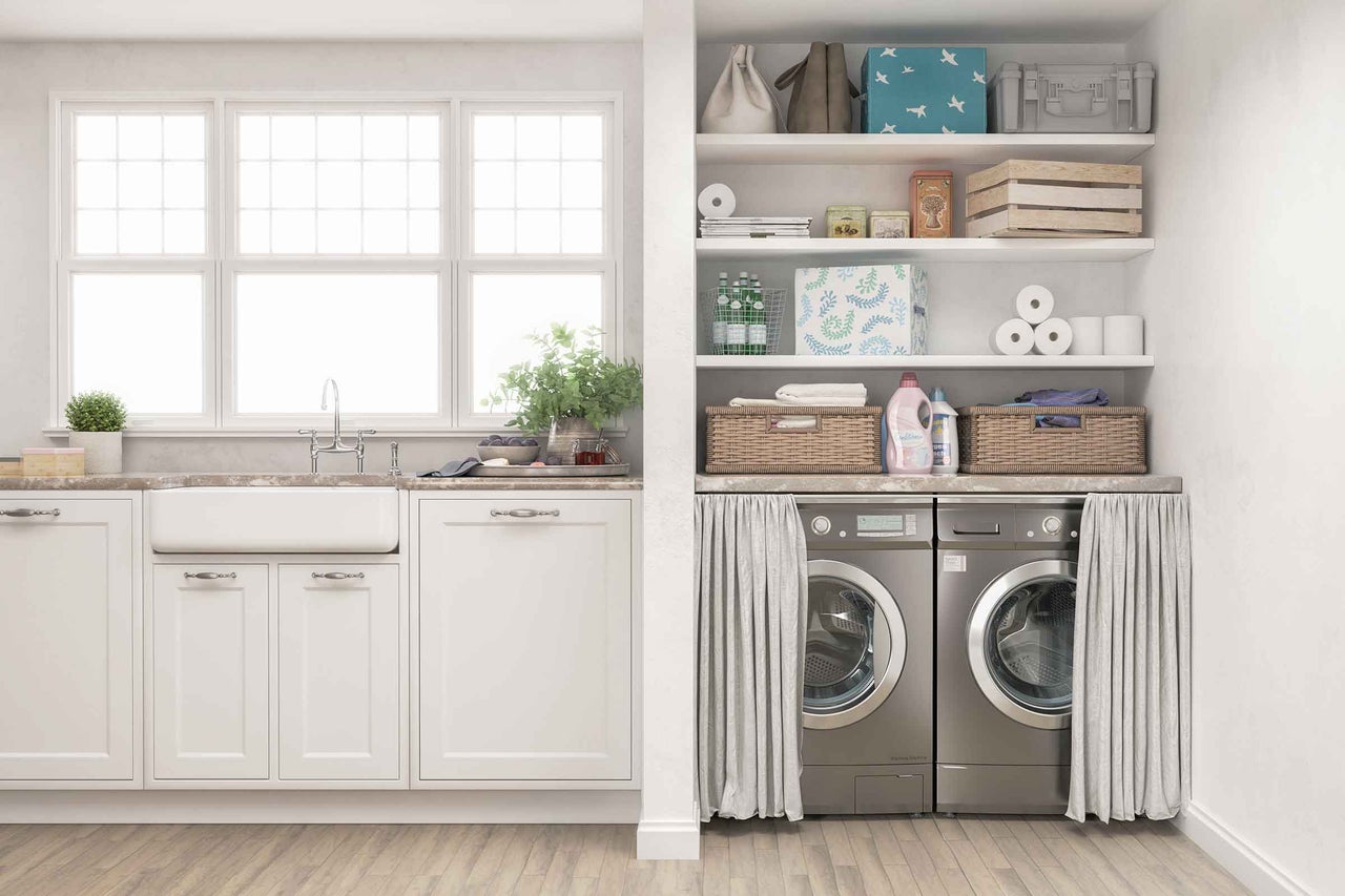 Buanderie lumineuse avec évier, lave-linge, sèche-linge et étagères de rangement