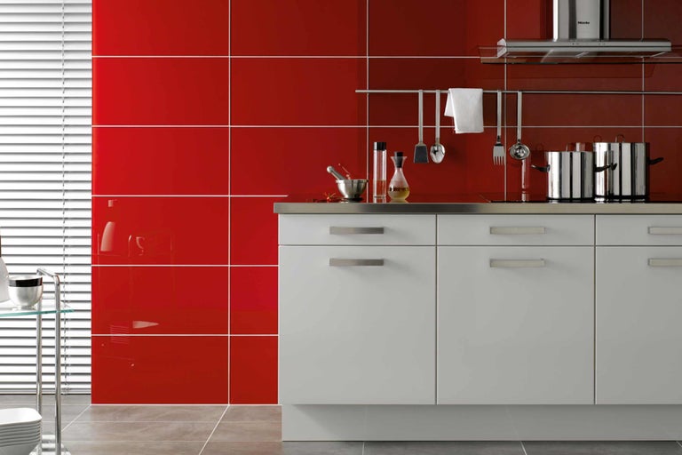Moderne Küche mit roten Wandfliesen und weißen Schränken