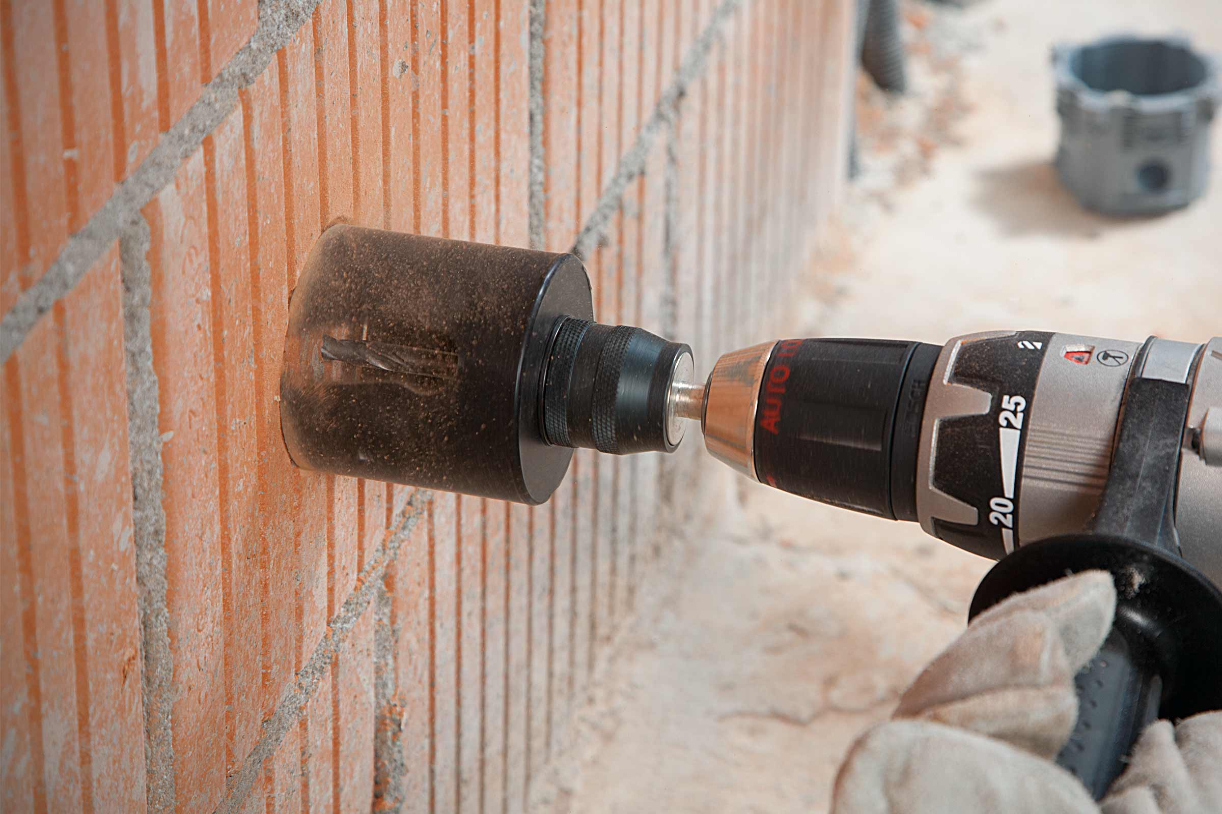 Une perceuse perce un trou dans un mur de briques.