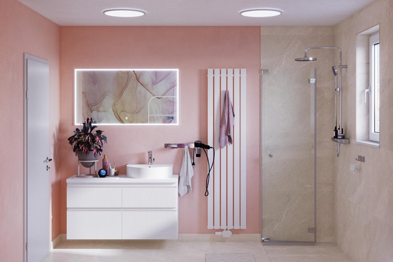 Salle de bain lumineuse avec lavabo, miroir, radiateur et douche