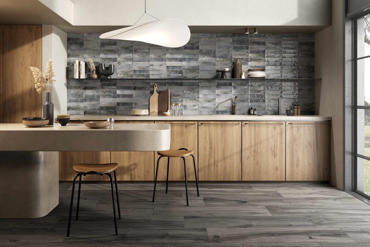 Helle Küche mit Holzelementen, grauen Fliesen und modernen Stühlen