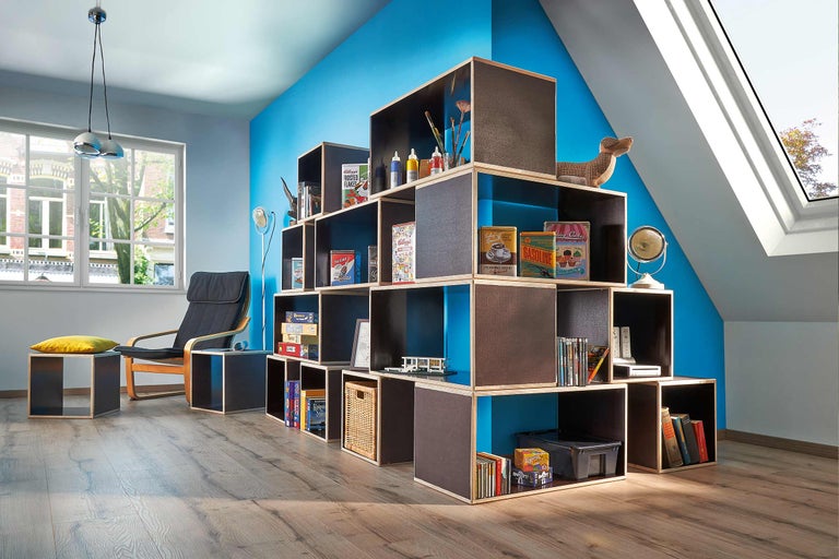 Espace de vie avec système de rangement, fauteuil et décoration pour une ambiance lumineuse et moderne