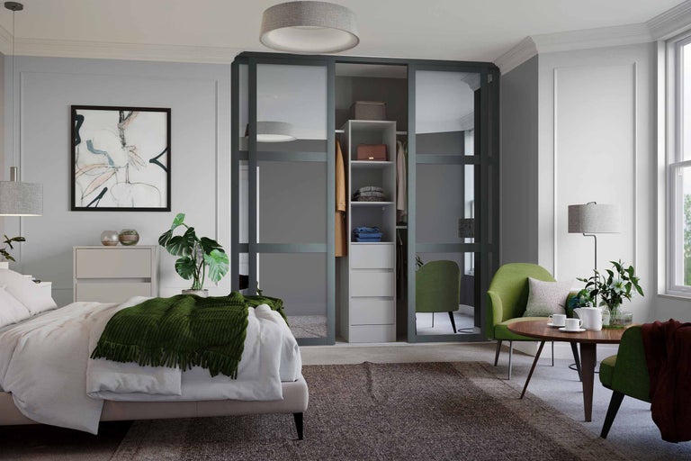 Schlafzimmer mit Bett, Kommode, Schiebetürenschrank und Sitzgruppe