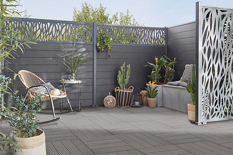 Gestalteter Aussenbereich mit Sichtschutz, Gartenmöbeln und Bodenfliesen