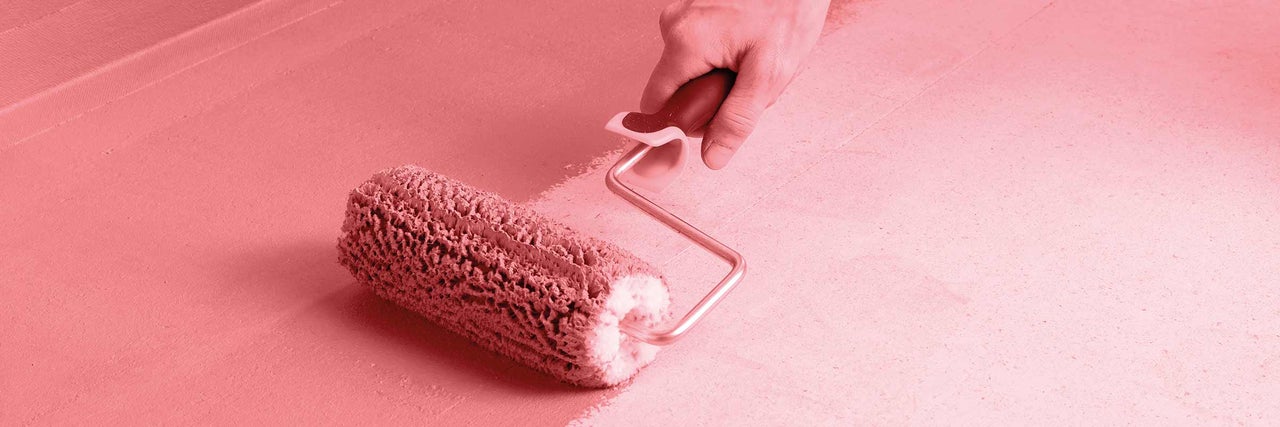 Une personne peint une surface avec un rouleau à peinture.