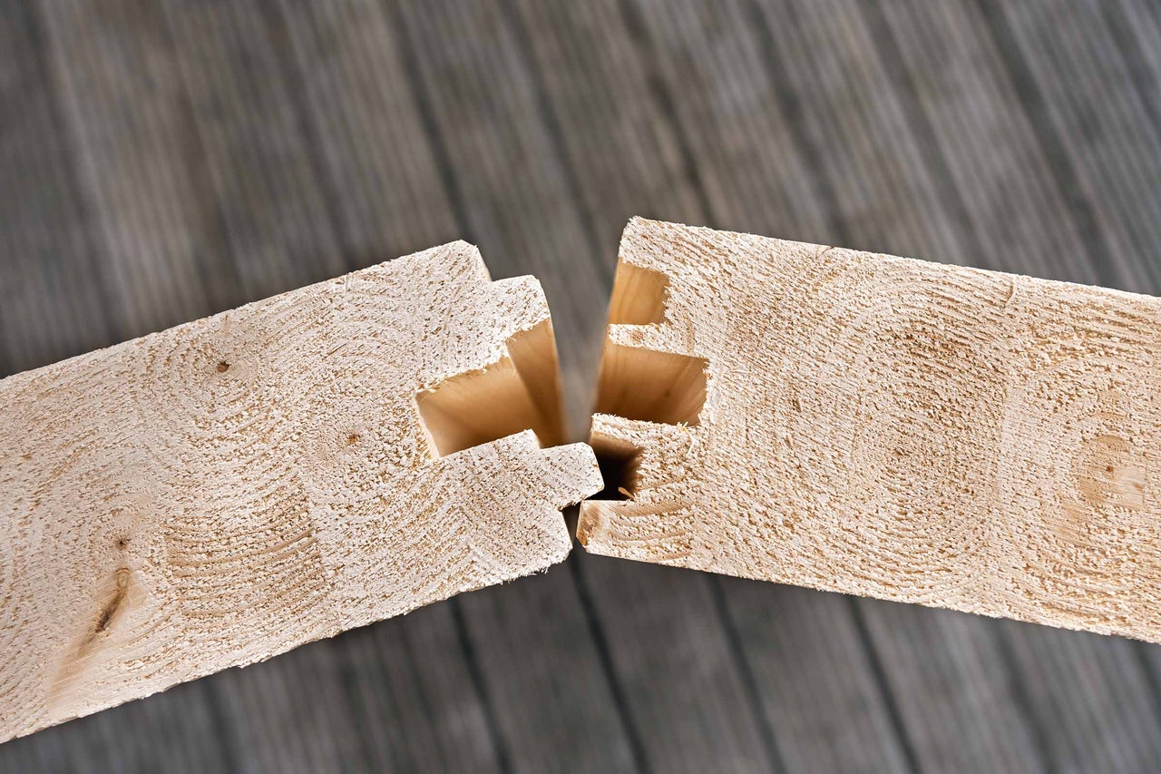 Assemblage de deux poutres en bois par une entaille précise pour des constructions en bois stables.