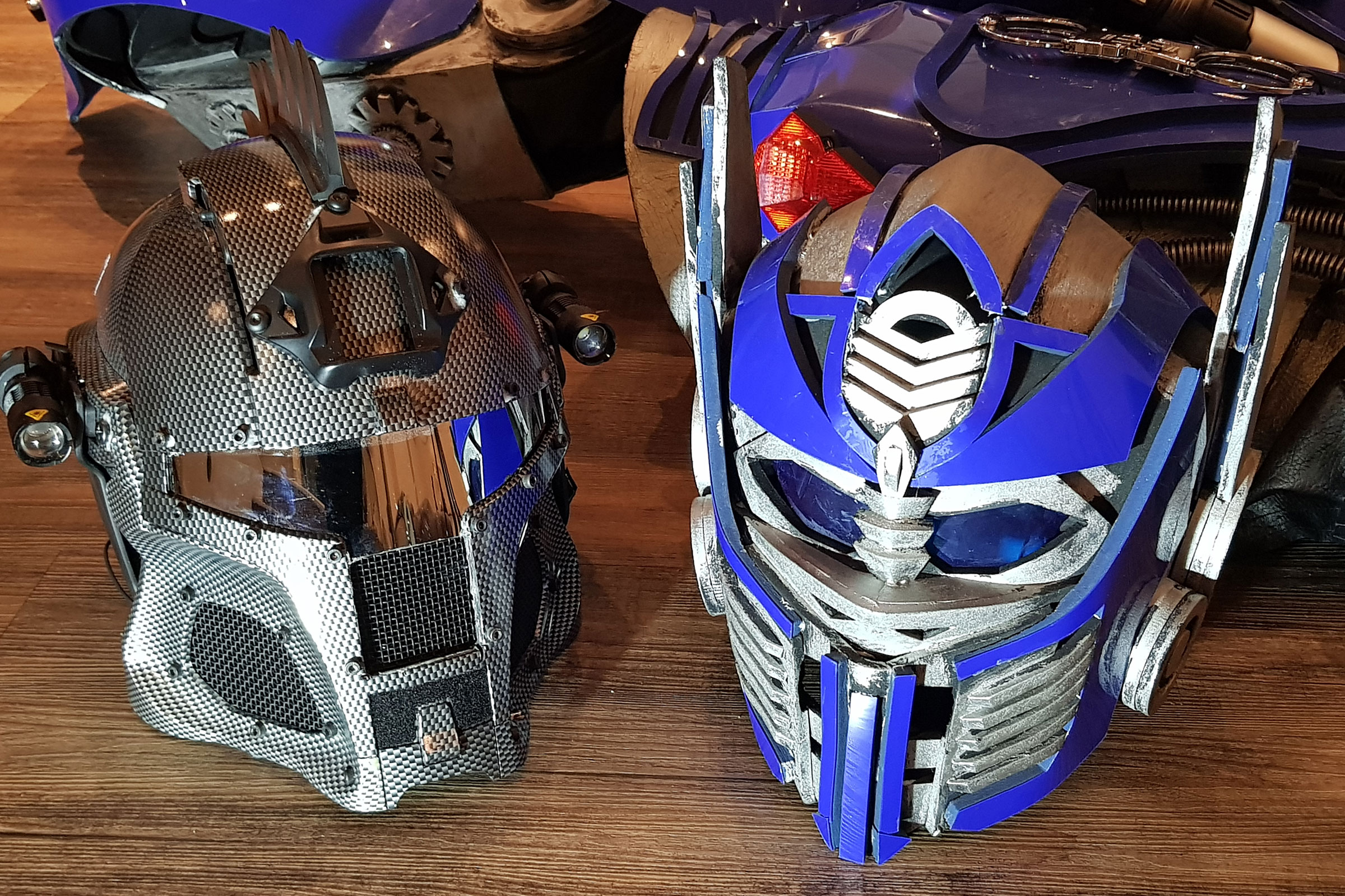 Zwei Transformers-Helme auf einem Holzboden