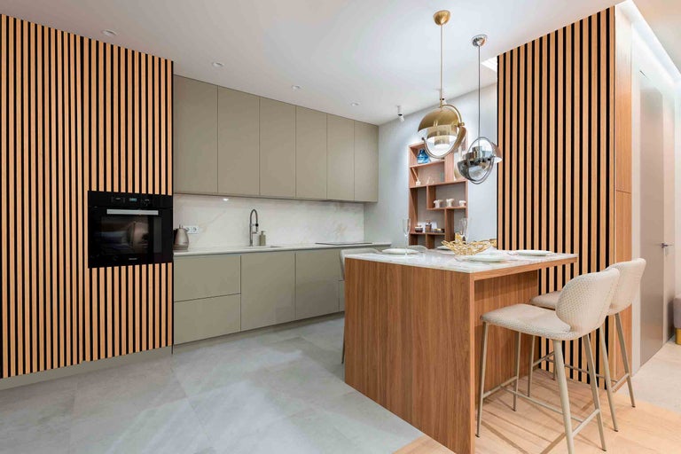 Cuisine moderne avec îlot de cuisine, four encastrable et panneaux de bois