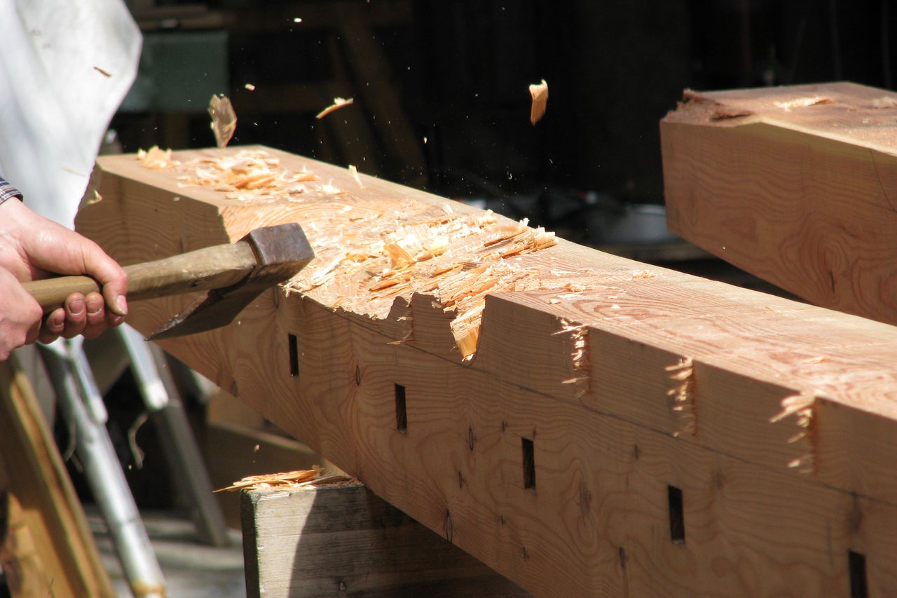 Travail du bois à la hache sur une poutre en bois