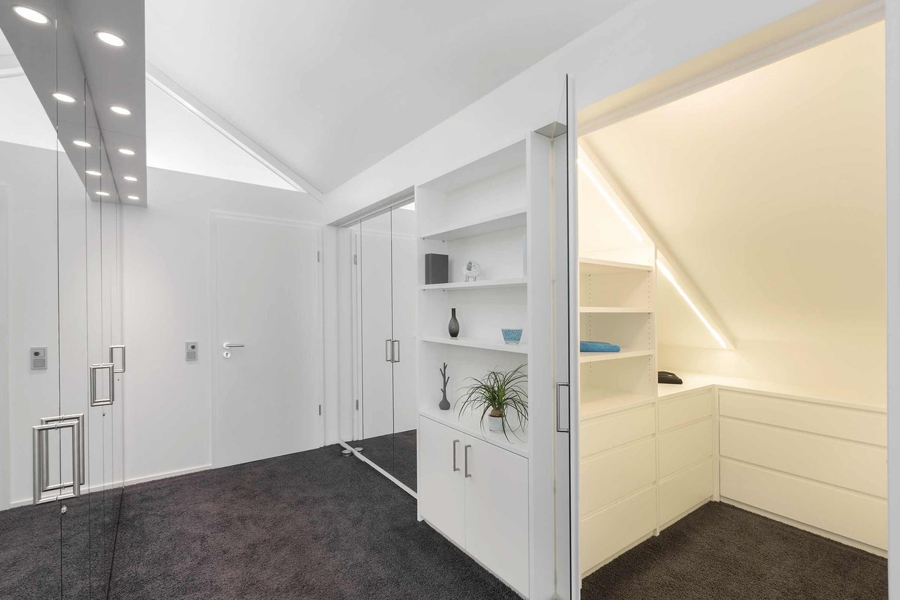 Dressing lumineux avec système de porte coulissante et éléments d'étagère.