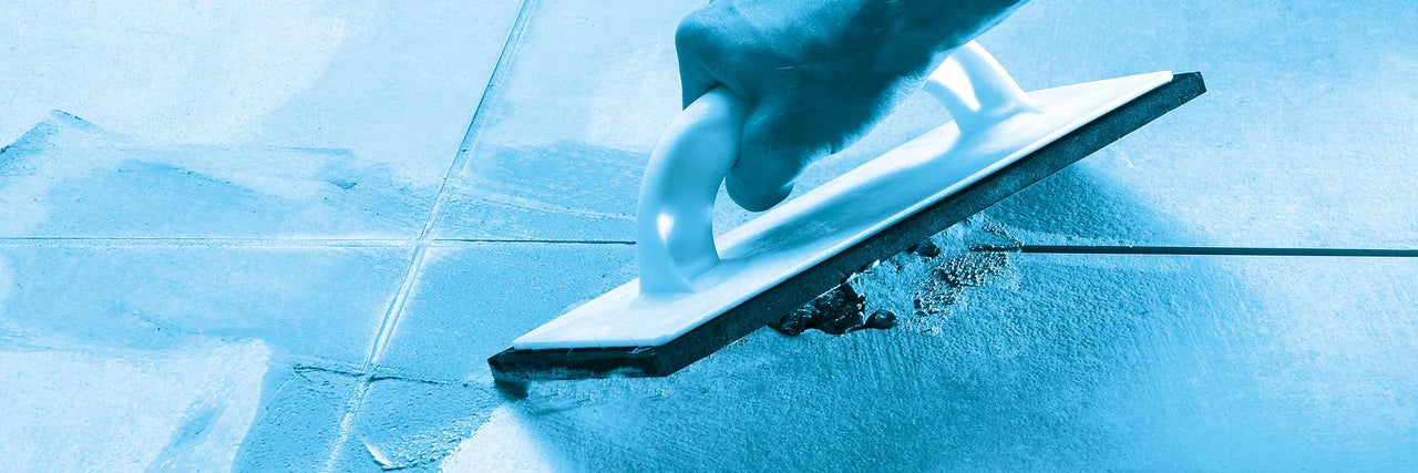 Carreleur travaillant avec du caoutchouc à joints